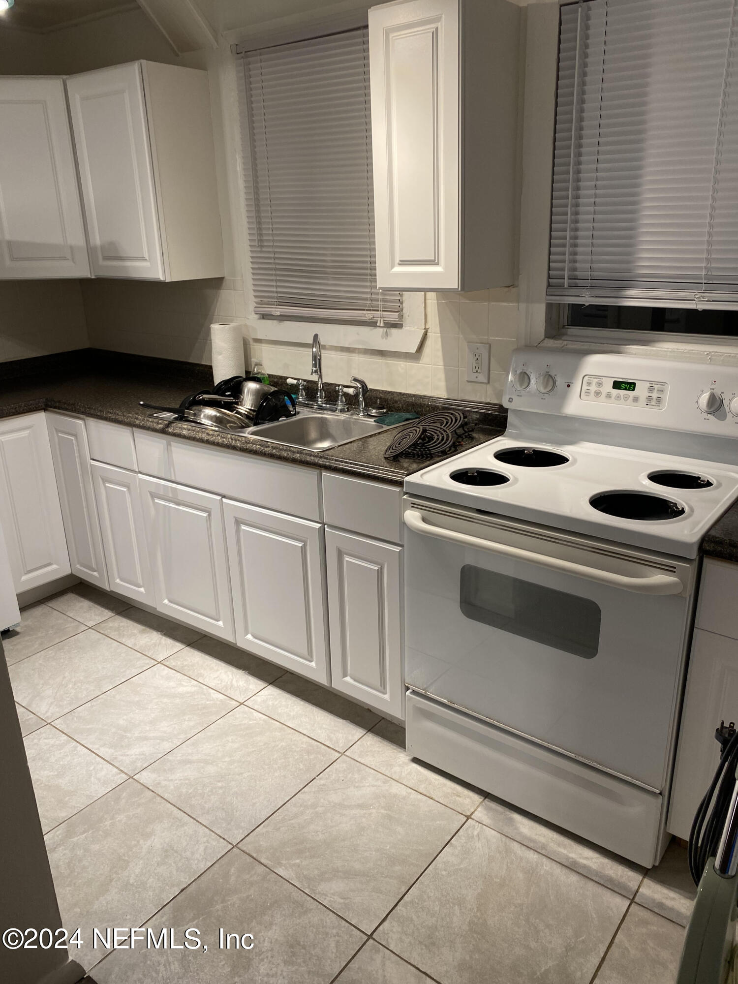 725 Cherokee Street Jacksonville, FL 32205 - Photo 37 of 41 a kitchen with granite countertop a stove sink and cabinets