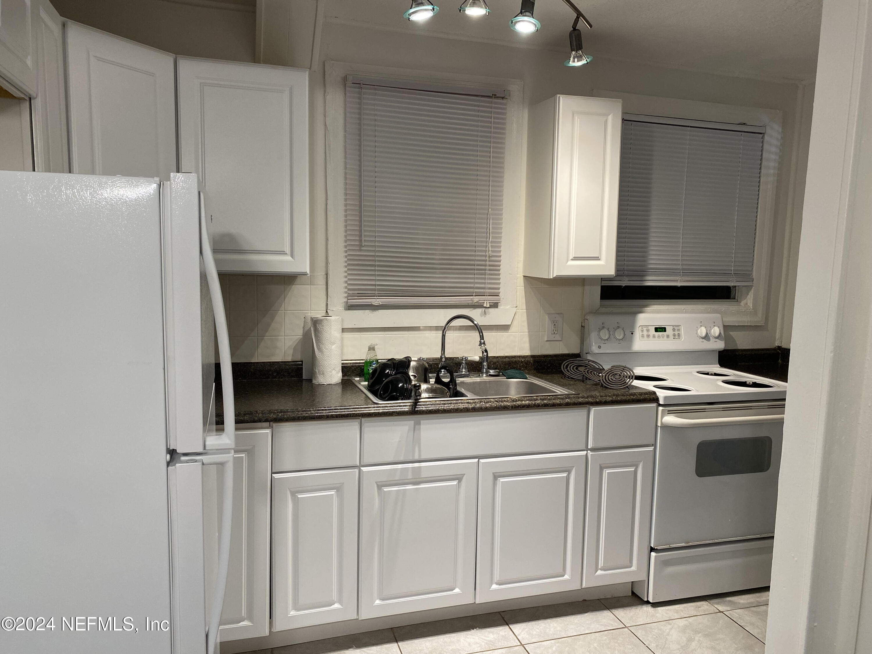 725 Cherokee Street Jacksonville, FL 32205 - Photo 38 of 41 a kitchen with granite countertop cabinets and white appliances