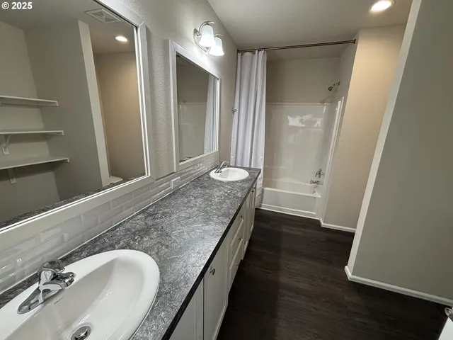 a bathroom with a granite countertop toilet sink and mirror