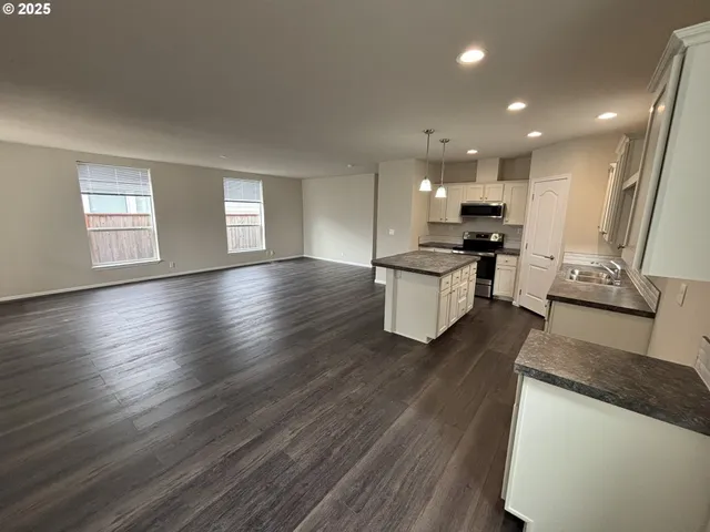 a kitchen with stainless steel appliances granite countertop wooden floors and stove