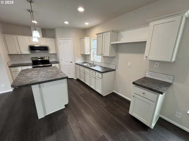 a kitchen with stainless steel appliances granite countertop a stove a sink and a refrigerator