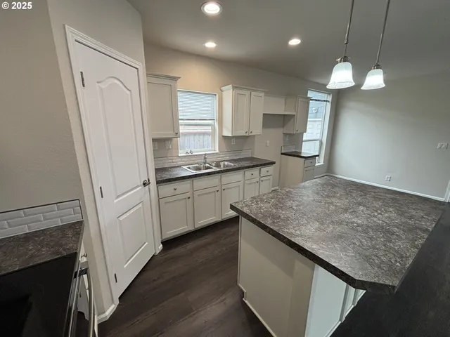 a kitchen with kitchen island a sink stainless steel appliances and cabinets