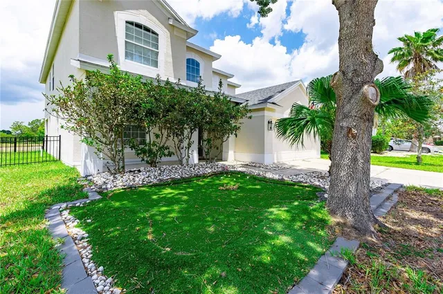 a view of a house with a yard and potted plants