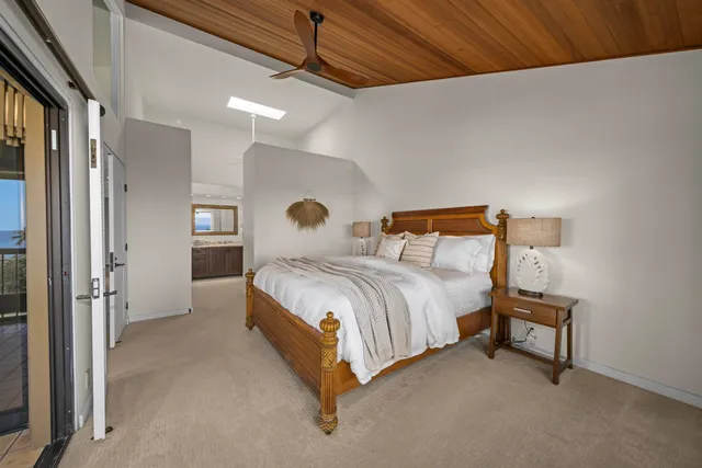 a spacious bedroom with a bed and a lamp