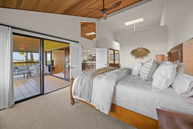 a spacious bedroom with a bed and glass door