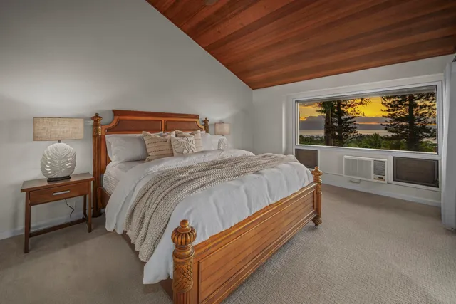 a bed sitting in a bedroom next to a large window