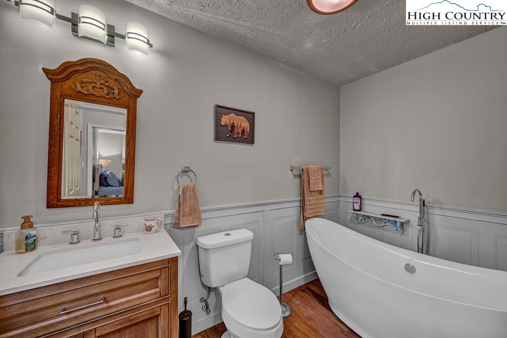607 Charter Hills Road Beech Mountain, NC 28604 - Photo 10 of 31 a bathroom with a sink a toilet and mirror