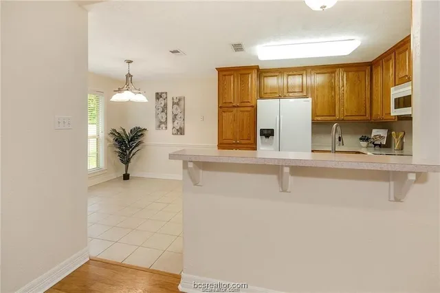a kitchen with a refrigerator a stove top oven and cabinets