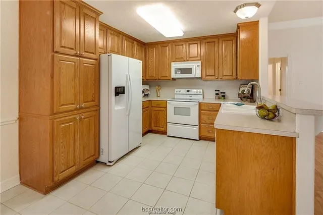 a view of cabinets a sink and a microwave