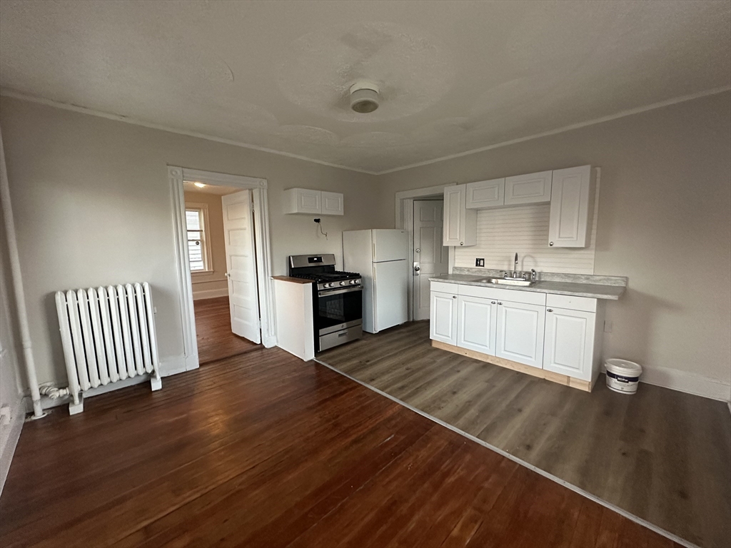 26 North Main Street, Unit 4 Natick, MA 01760 - Photo 5 of 13 a kitchen with wooden floors and white appliances