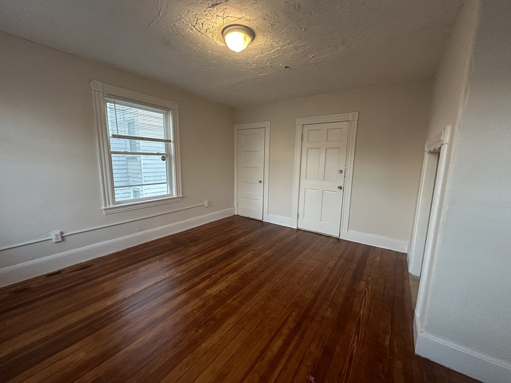 26 North Main Street, Unit 4 Natick, MA 01760 - Photo 6 of 13 an empty room with wooden floor and windows