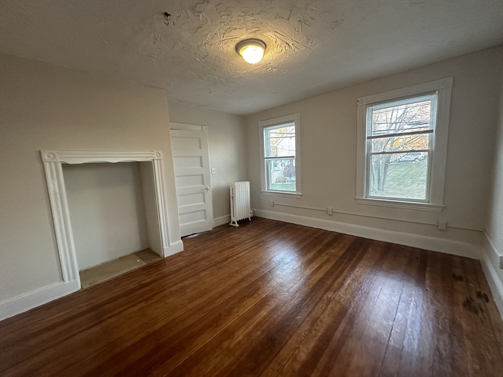 26 North Main Street, Unit 4 Natick, MA 01760 - Photo 7 of 13 an empty room with wooden floor and windows
