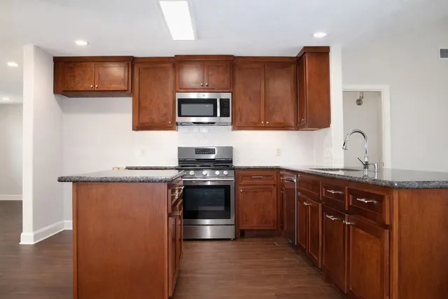 a kitchen with stainless steel appliances granite countertop a refrigerator and a sink