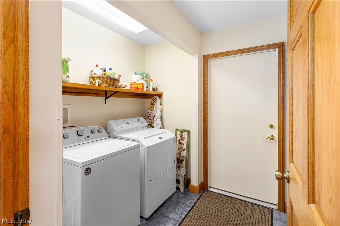 10909 Ruby Road Cambridge, OH 43725 - Photo 10 of 34 Laundry room with dark tile patterned floors and washing machine and clothes dryer