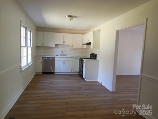 a view of a kitchen with wooden floor and electronic appliances