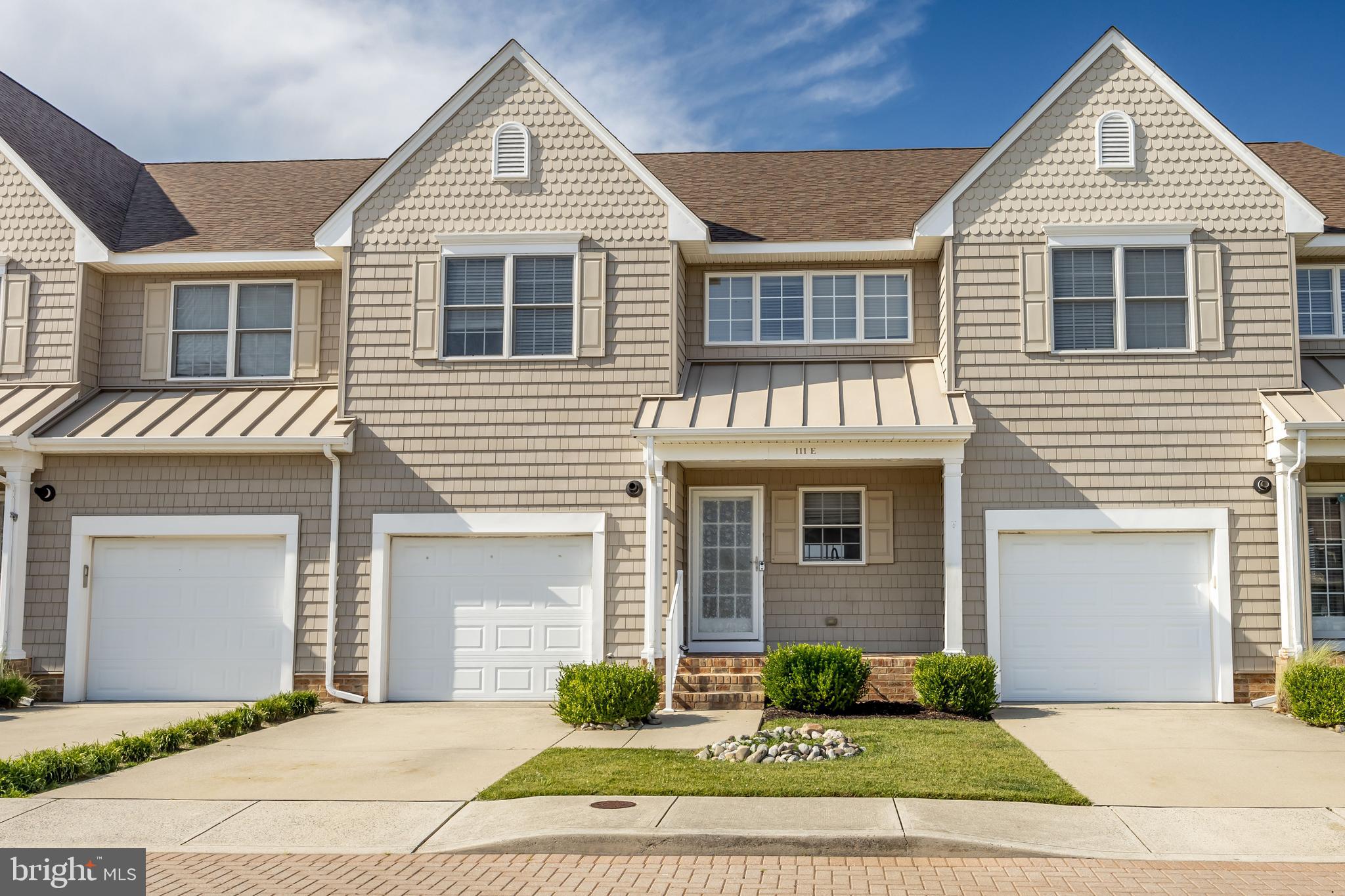 111 Sunset Circle, Unit 111E Crisfield, MD 21817 - Photo 15 of 57 a front view of a house with a yard and garage