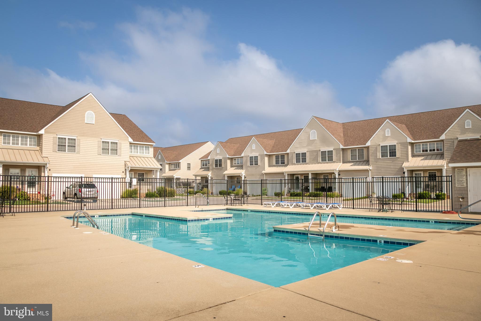 111 Sunset Circle, Unit 111E Crisfield, MD 21817 - Photo 16 of 57 a view of an house with swimming pool and lounge chairs