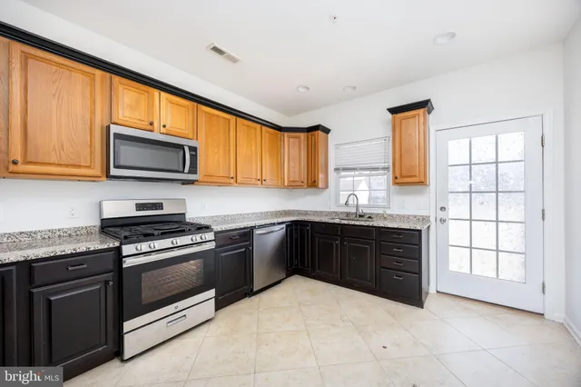 a kitchen with stainless steel appliances granite countertop a refrigerator and a sink