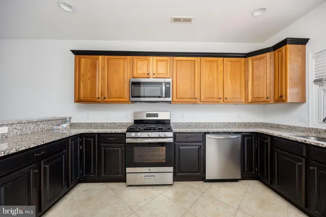 a large kitchen with a stove a sink and a refrigerator