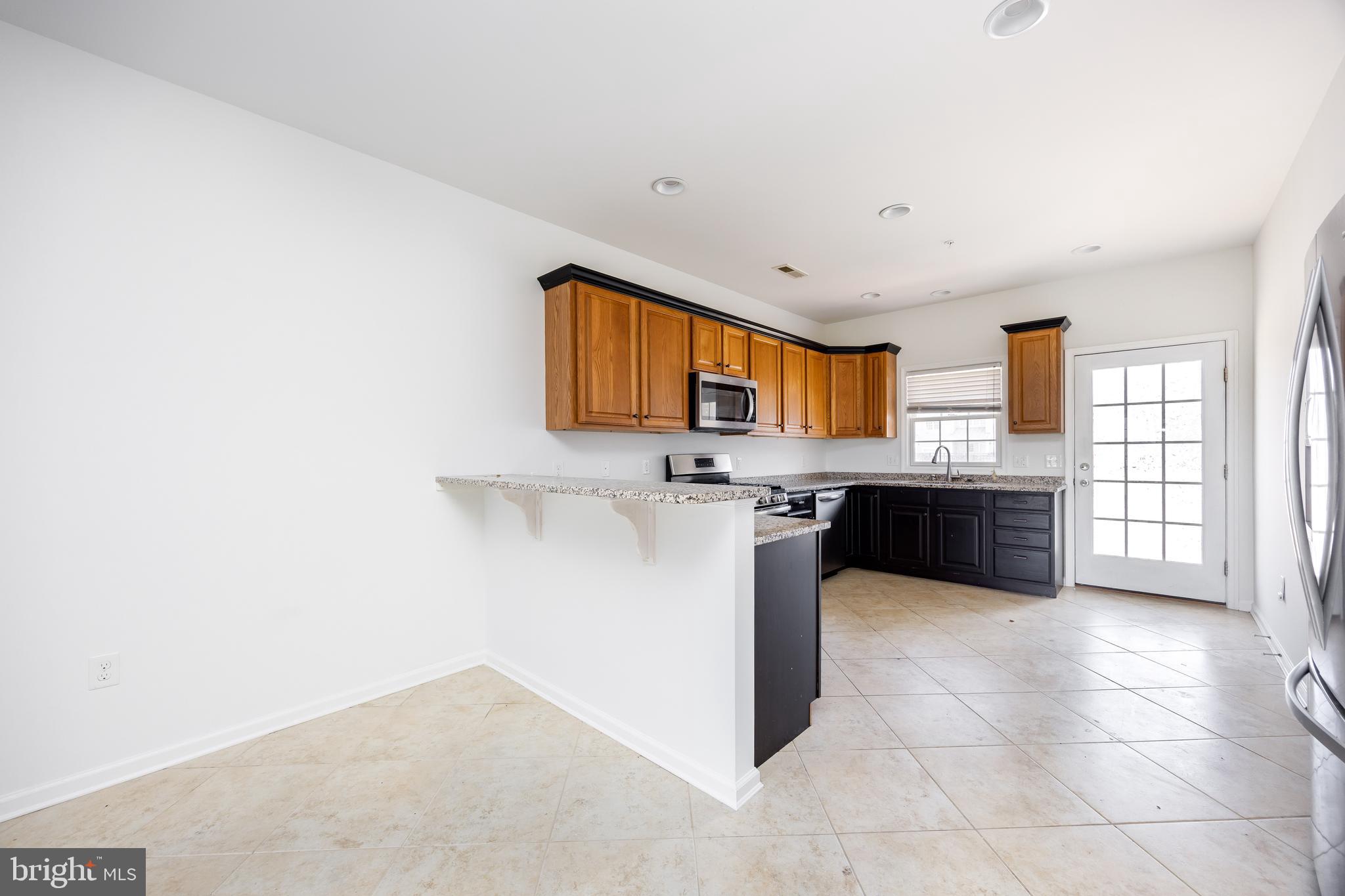 111 Sunset Circle, Unit 111E Crisfield, MD 21817 - Photo 23 of 57 a large kitchen with a stove a sink and a refrigerator