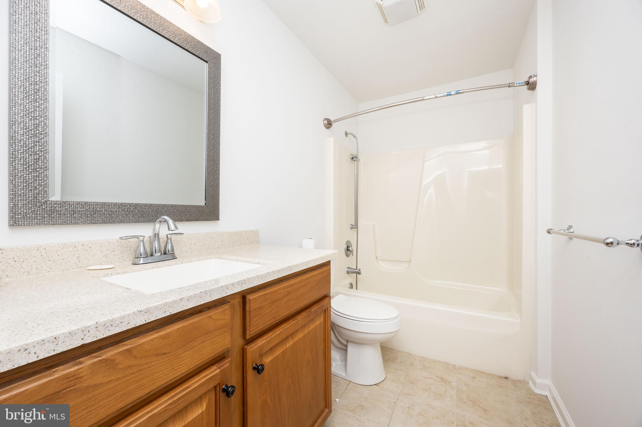111 Sunset Circle, Unit 111E Crisfield, MD 21817 - Photo 38 of 57 a bathroom with a granite countertop sink a toilet and shower
