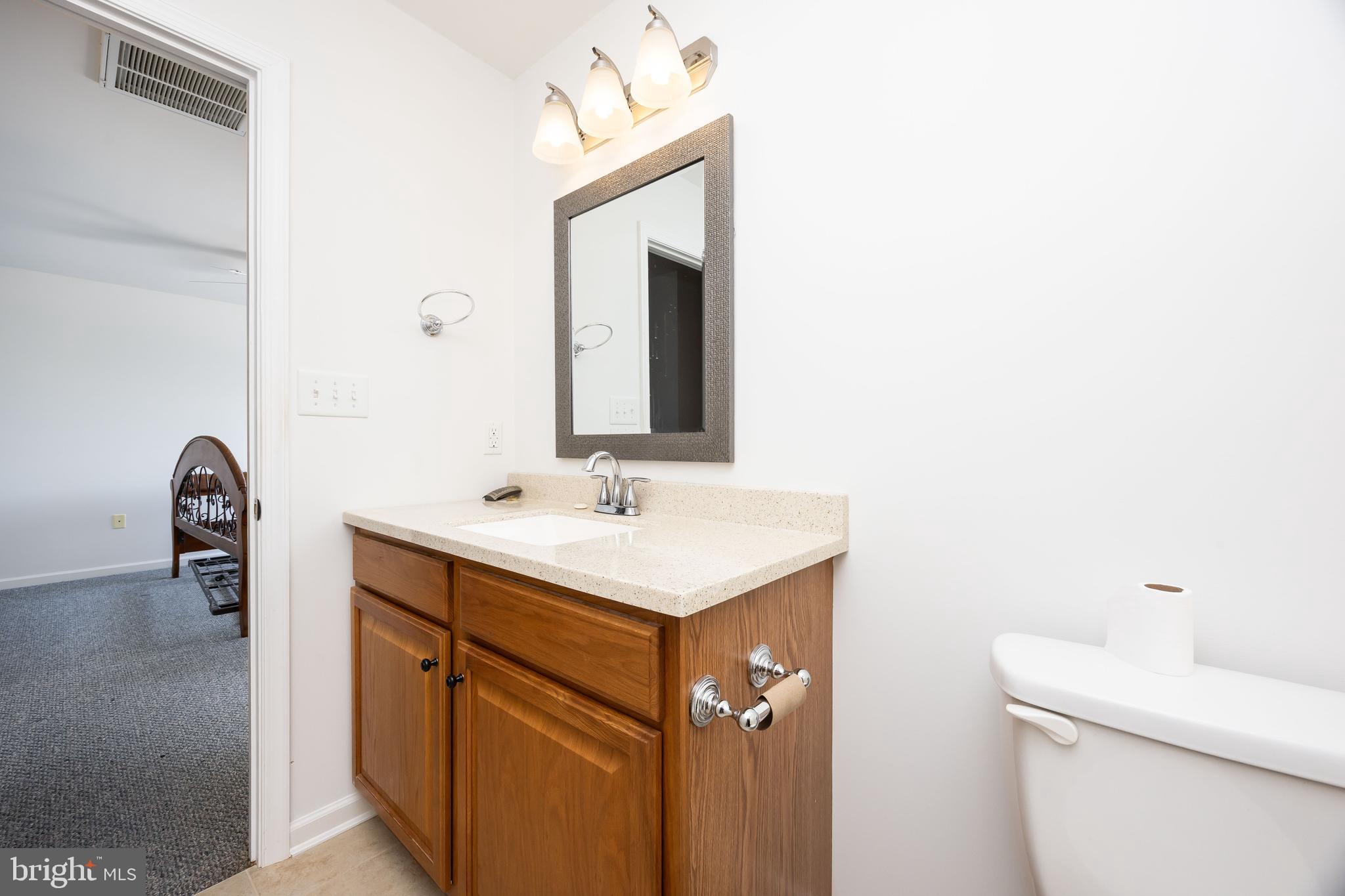 111 Sunset Circle, Unit 111E Crisfield, MD 21817 - Photo 39 of 57 a bathroom with a toilet sink and mirror