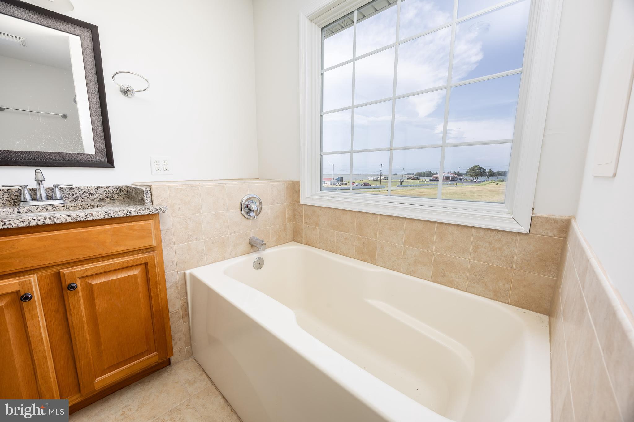 111 Sunset Circle, Unit 111E Crisfield, MD 21817 - Photo 47 of 57 a bathroom with a tub sink and mirror