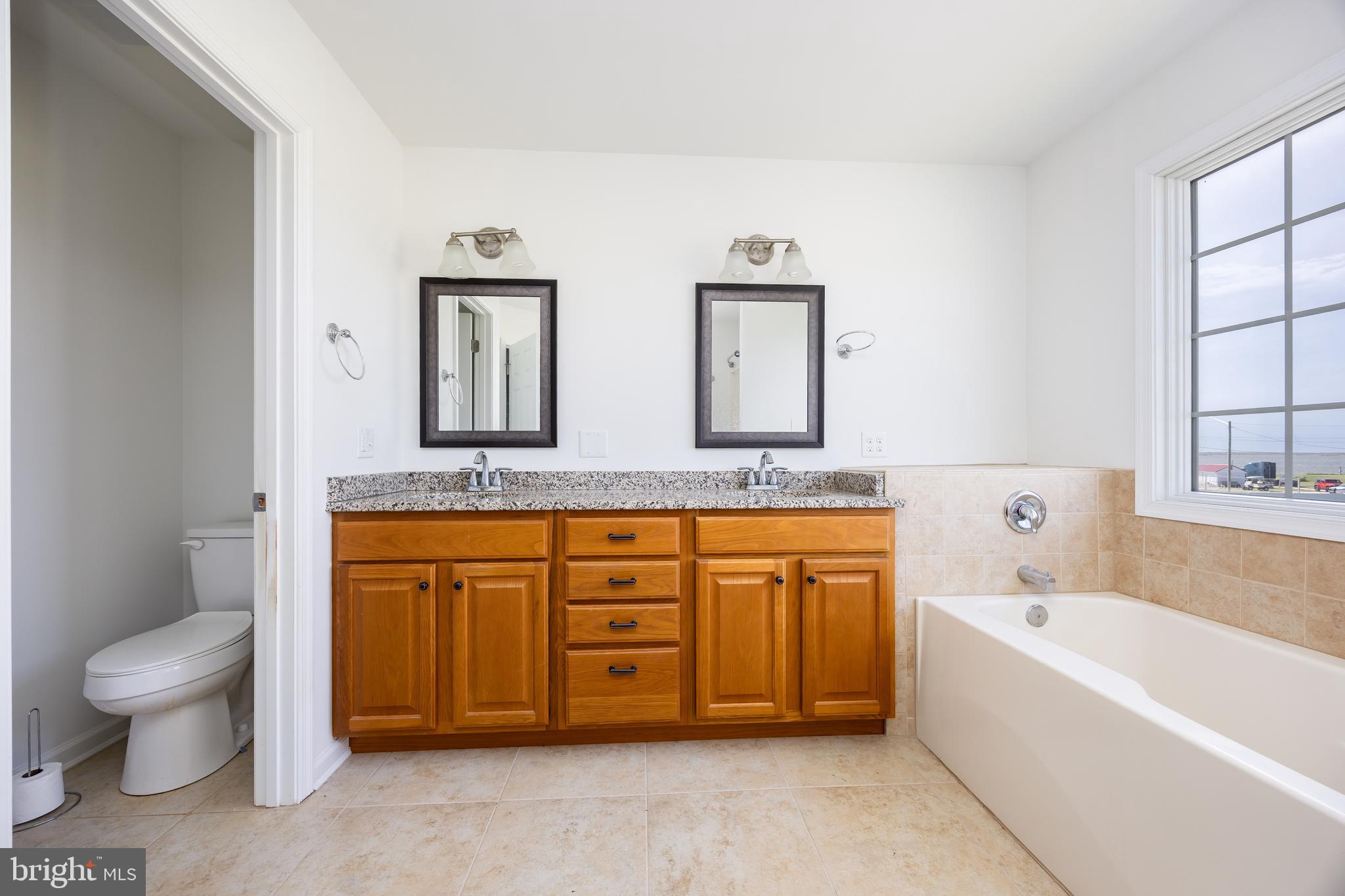 111 Sunset Circle, Unit 111E Crisfield, MD 21817 - Photo 48 of 57 a spacious bathroom with a granite countertop tub sink and mirror