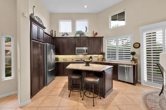 a kitchen with kitchen island stainless steel appliances a sink and counter space