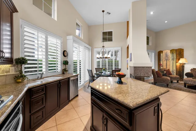 a kitchen with granite countertop kitchen island stainless steel appliances a sink stove and cabinets