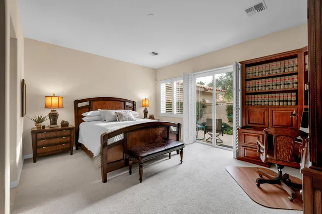 a bedroom with a bed and large windows