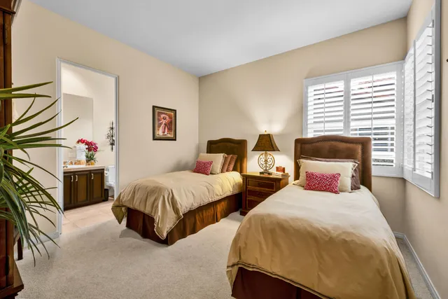 a bedroom with two beds and painting on the wall