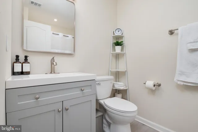 a bathroom with a sink a toilet and mirror