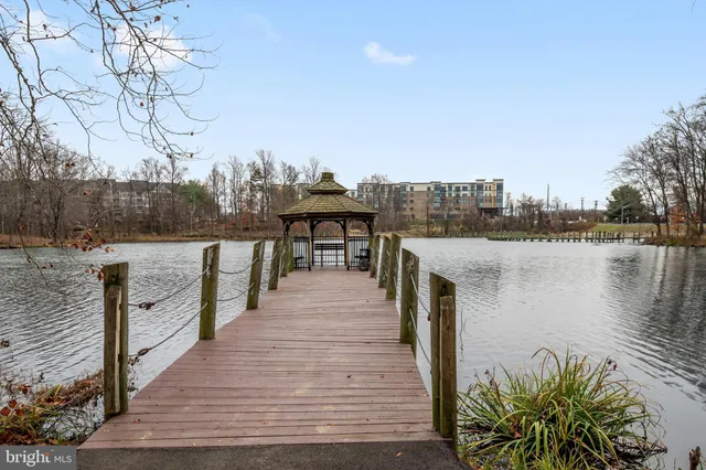 a lake view with tables and chairs next to a yard