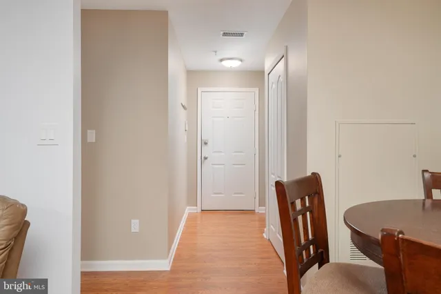 a view of a hallway with chairs and wooden floor
