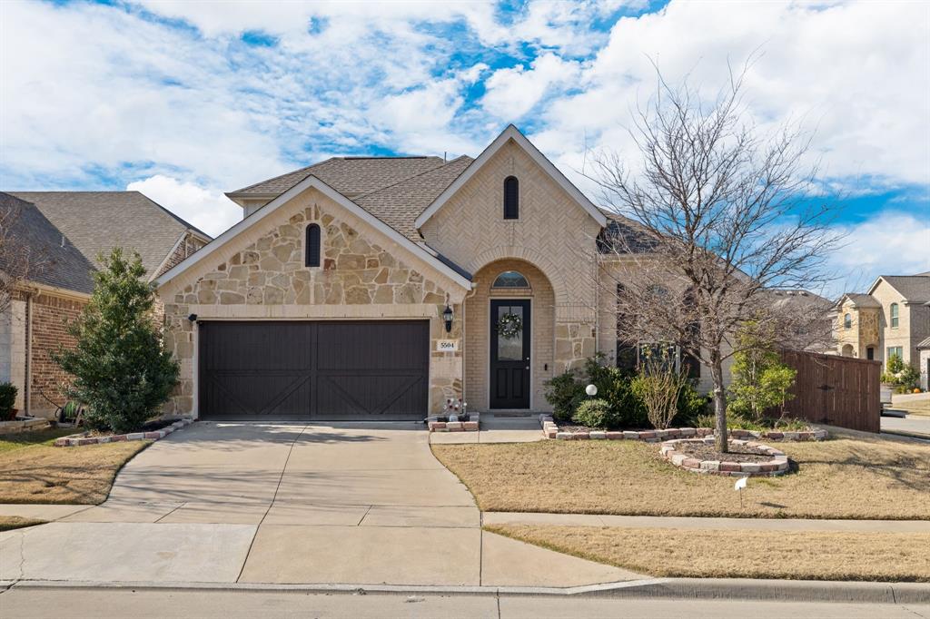 a front view of a house with garage and trees
