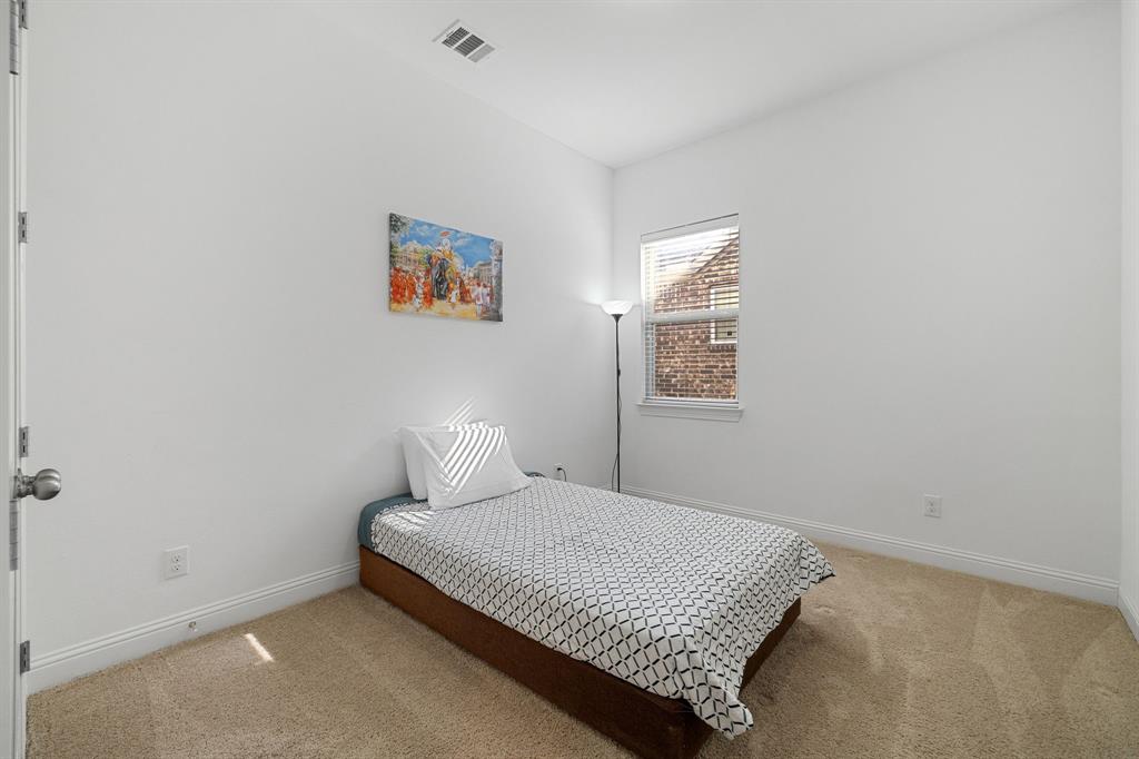 5504 Ripasso Street McKinney, TX 75070 - Photo 20 of 40 a bedroom with a bed and night stand