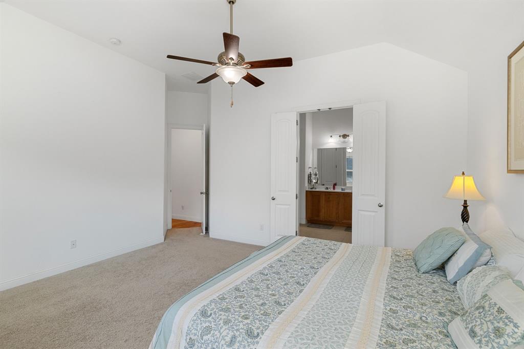 5504 Ripasso Street McKinney, TX 75070 - Photo 26 of 40 a bedroom with a bed and a chandelier