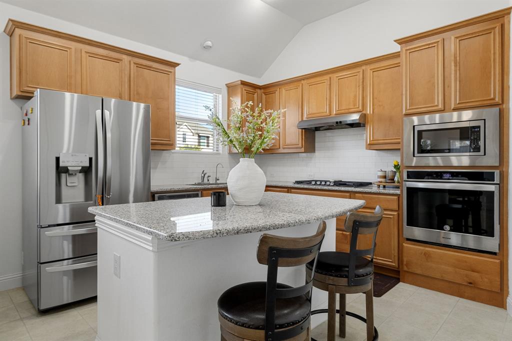 5504 Ripasso Street McKinney, TX 75070 - Photo 8 of 40 a kitchen with stainless steel appliances granite countertop a refrigerator a stove a sink and a microwave