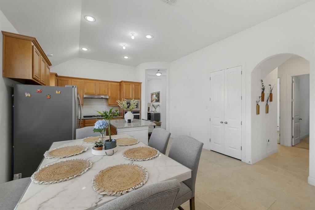 5504 Ripasso Street McKinney, TX 75070 - Photo 10 of 40 a dining room with furniture a mirror and wooden floor