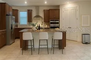 a kitchen with stainless steel appliances granite countertop a refrigerator and a stove