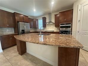 7845 Wandering Way Orlando, FL 32836 - Photo 16 of 61 a kitchen with kitchen island granite countertop a sink stove and refrigerator
