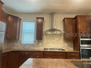 7845 Wandering Way Orlando, FL 32836 - Photo 18 of 61 a kitchen with stainless steel appliances wooden cabinets and a counter top space