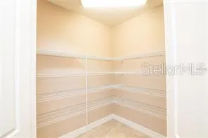 an empty room with closet and a chandelier fan