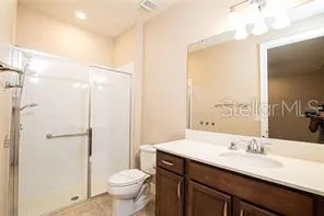 a bathroom with a granite countertop sink a toilet and a mirror