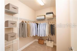 7845 Wandering Way Orlando, FL 32836 - Photo 37 of 61 a view of walk in closet with clothes and shoes