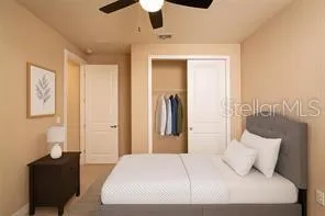 a spacious bedroom with a bed a couch and a flat screen tv