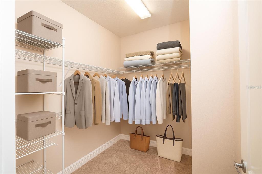 7845 Wandering Way Orlando, FL 32836 - Photo 56 of 61 a view of walk in closet with clothes and shoes
