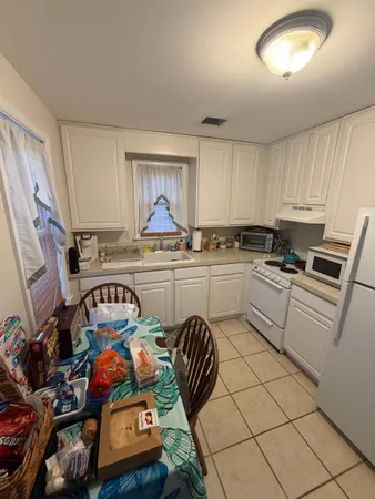 a kitchen with stainless steel appliances a sink a stove a refrigerator cabinets and a window