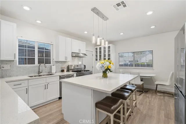 a kitchen with a sink appliances and cabinets